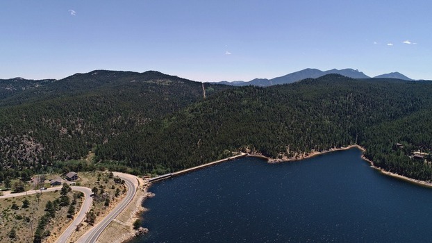 Aerial view of Barker Meadow Reservoir surrounded by dense pine forests winding roads and mountainous terrain in Boulder County Colorado United States. Aerial view of Barker Meadow Reservoir surrounded by dense pine forests winding roads and mountainous terrain in Boulder County Colorado United States.