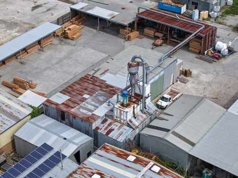 Melbourne VIC Australia 25 September 2026 Aerial view of an industrial factory site featuring stacks of timber metal roofing machinery and a white utility vehicle.