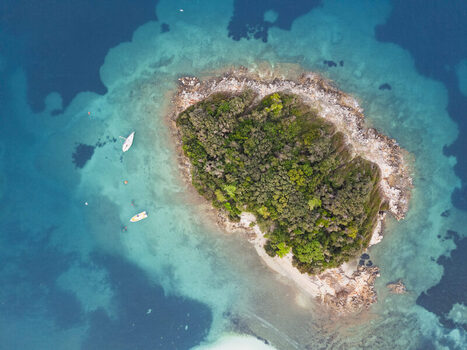 Aerial view of the Ksamil islands surrounded by turquoise waters with small boats anchored nearby in Ksamil Vlore County Albania. Aerial view of the Ksamil islands surrounded by turquoise waters with small boats anchored nearby in Ksamil Vlore County Albania.