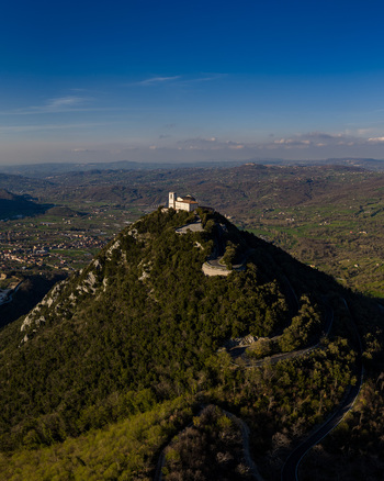 Aerial view of the Santuario del Santissimo Salvatore on a forested hilltop with a winding road and the valley below Montella Campania Italy. Aerial view of the Santuario del Santissimo Salvatore on a forested hilltop with a winding road and the valley below Montella Campania Italy.