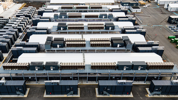 Aerial view of a large data center facility with rows of modular server units cooling systems and industrial infrastructure in Keflavik Reykjanesbaer Iceland. Aerial view of a large data center facility with rows of modular server units cooling systems and industrial infrastructure in Keflavik Reykjanesbaer Iceland.