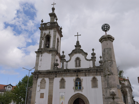 View of the historic Igreja de Nossa Senhora da Conceicao da Covilha with its stone bell tower and ornate facade under a cloudy sky in Covilha Castelo Branco Portugal.