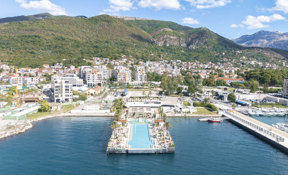 Aerial view of the Lido Mar infinity pool at Porto Montenegro marina surrounded by luxury yachts coastal buildings and mountains in Tivat Tivat Municipality Montenegro. Aerial view of the Lido Mar infinity pool at Porto Montenegro marina surrounded by luxury yachts coastal buildings and mountains in Tivat Tivat Municipality Montenegro.
