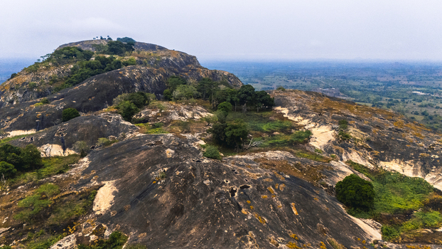 Aerial view of a rocky outcrop dotted with green vegetation contrasting against the hazy horizon IYAKE LAKE Oyo Nigeria. Aerial view of a rocky outcrop dotted with green vegetation contrasting against the hazy horizon IYAKE LAKE Oyo Nigeria.