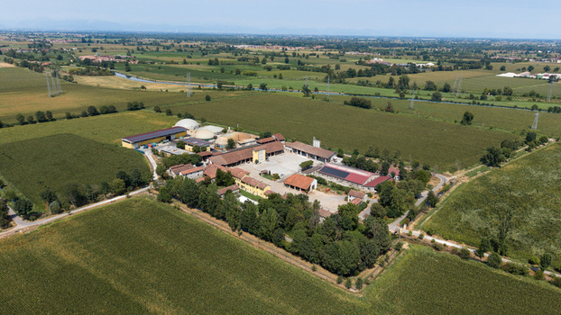 Aerial view of a biomethane production facility integrated with agricultural buildings and solar panels in a rural landscape in Tavazzano con Villavesco Lombardy Italy.