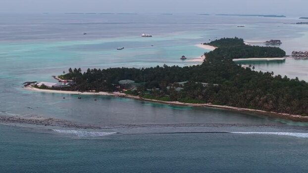 Aerial view of the tropical resort island with palm trees and beaches Maldives. Aerial view of the tropical resort island with palm trees and beaches Maldives.