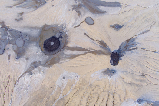 Aerial view of the mud volcanoes at Vulcanii Noroiosi Paclele Mari showcasing unique geological formations grey mud craters and dry cracked earth patterns in Paclele Buzau County Romania.