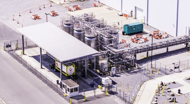 Aerial view of a bulk chemical storage and transfer area featuring stainless steel tanks industrial piping and a loading bay at a facility in Spring Hill TN United States. Aerial view of a bulk chemical storage and transfer area featuring stainless steel tanks industrial piping and a loading bay at a facility in Spring Hill TN United States.