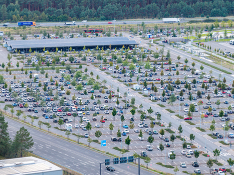Aerial view of the Tesla Gigafactory Berlin Brandenburg parking lot filled with numerous cars surrounded by trees and adjacent to a highway in Grunheide Mark Brandenburg Germany. Aerial view of the Tesla Gigafactory Berlin Brandenburg parking lot filled with numerous cars surrounded by trees and adjacent to a highway in Grunheide Mark Brandenburg Germany.