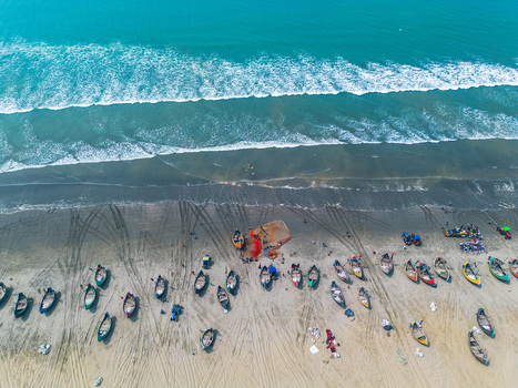 Aerial view of fishing boats scattered on the sandy shore where the turquoise sea meets the land Cox s Bazar Chittagong Division Bangladesh.