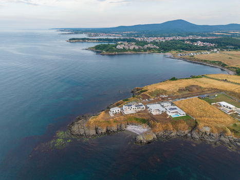 Aerial view of modern villas on the rocky cliffs of Arapya surrounded by golden fields and the Black Sea in Burgas Bulgaria. Aerial view of modern villas on the rocky cliffs of Arapya surrounded by golden fields and the Black Sea in Burgas Bulgaria.
