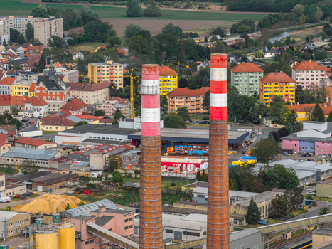 Aerial view of Tepelna elektrarna Hodonin power station with tall chimneys overlooking colorful residential buildings and urban landscape in Hodonin Jihomoravsky kraj Czechia. Aerial view of Tepelna elektrarna Hodonin power station with tall chimneys overlooking colorful residential buildings and urban landscape in Hodonin Jihomoravsky kraj Czechia.