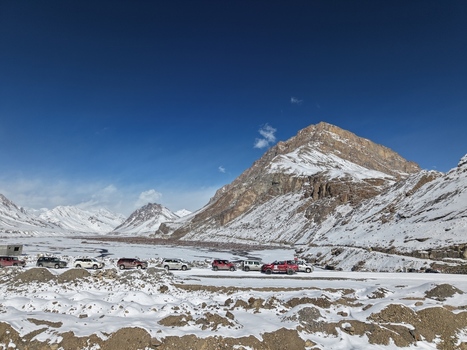 Kaza India 28 January 2026 View of a convoy of off road vehicles parked on a snowy road in the Spiti Valley surrounded by rugged snow covered mountains under a clear blue sky. Kaza India 28 January 2026 View of a convoy of off road vehicles parked on a snowy road in the Spiti Valley surrounded by rugged snow covered mountains under a clear blue sky.