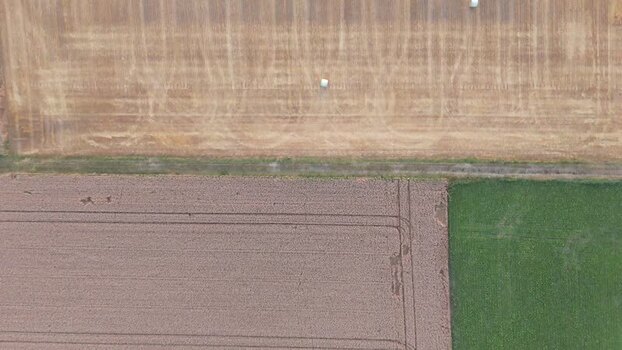 Aerial view of agricultural fields and hay bales in rural Geneva Switzerland.