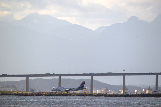 Rio de Janeiro Brazil 05 June 2026 View of a LATAM Airlines plane taxiing at Santos Dumont Airport with the Rio Niteroi Bridge and misty mountains in the background.