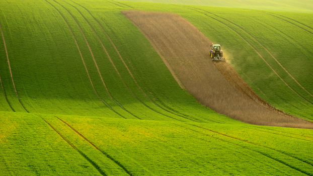 View of a tractor plowing a field in the rolling hills of Moravia Brno City District South Moravian Region Czechia.