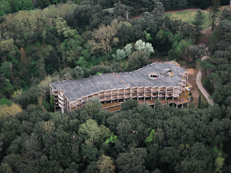Aerial view of an abandoned multi story concrete building surrounded by dense green forest in Leccio Toscana Italy. Aerial view of an abandoned multi story concrete building surrounded by dense green forest in Leccio Toscana Italy.