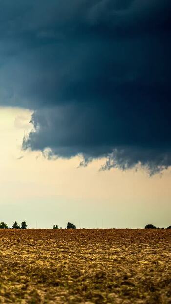 View of storm clouds over a plowed field in Latvia. View of storm clouds over a plowed field in Latvia.