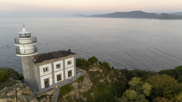 Aerial view of Getariako Itsasargia lighthouse perched on a rocky cliff overlooking the calm sea at sunset in Getaria Euskadi Spain. Aerial view of Getariako Itsasargia lighthouse perched on a rocky cliff overlooking the calm sea at sunset in Getaria Euskadi Spain.