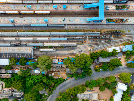 Aerial view of Udaipur railway station with multiple passenger trains on tracks platforms and surrounding greenery in Udaipur Rajasthan India. Aerial view of Udaipur railway station with multiple passenger trains on tracks platforms and surrounding greenery in Udaipur Rajasthan India.