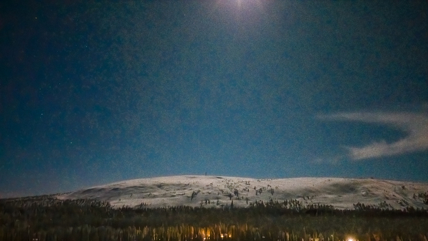 Aerial view of Luosto fell covered in snow under a starry night sky with the moon shining above the horizon in Sodankyla Lapland Finland. Aerial view of Luosto fell covered in snow under a starry night sky with the moon shining above the horizon in Sodankyla Lapland Finland.