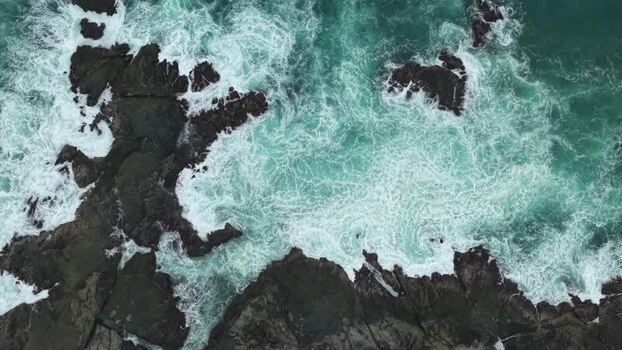 Aerial view of waves crashing on rocks at Siung Beach Indonesia.