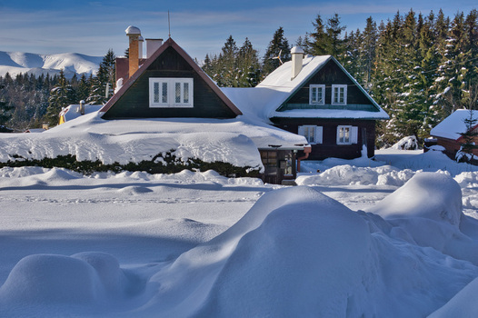 View of snow laden cabin roofs and pristine drifts under a crisp blue sky a winter haven nestled among dark green pines Donovaly Banskobystricky kraj Slovakia. View of snow laden cabin roofs and pristine drifts under a crisp blue sky a winter haven nestled among dark green pines Donovaly Banskobystricky kraj Slovakia.