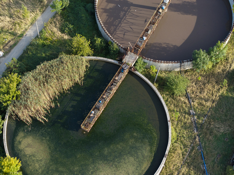 Aerial view of a wastewater treatment plant with large circular sedimentation tanks and metal walkways surrounded by greenery in Krakow Lesser Poland Voivode Poland.