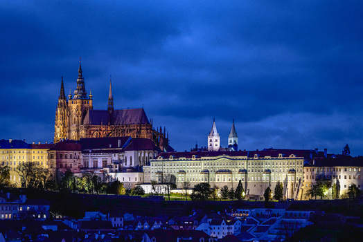 Aerial view of the illuminated St. Vitus Cathedral and Prague Castle complex at night featuring historic gothic architecture and glowing windows in Prague Prague Czechia. Aerial view of the illuminated St. Vitus Cathedral and Prague Castle complex at night featuring historic gothic architecture and glowing windows in Prague Prague Czechia.