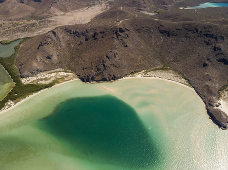 Aerial view of the turquoise waters and sandbars of Balandra beach surrounded by arid hills in La Paz Baja California Sur Mexico. Aerial view of the turquoise waters and sandbars of Balandra beach surrounded by arid hills in La Paz Baja California Sur Mexico.