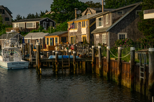 View of Martha s Vineyard featuring traditional wooden shingle houses and a boat docked at a pier during golden hour Edgartown Massachusetts United States.