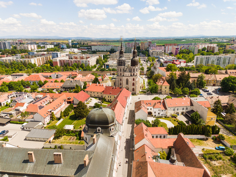 Aerial view of the historic St. Nicholas Basilica with its twin towers surrounded by red tiled rooftops and lush greenery in Trnava Trnava Region Slovakia. Aerial view of the historic St. Nicholas Basilica with its twin towers surrounded by red tiled rooftops and lush greenery in Trnava Trnava Region Slovakia.