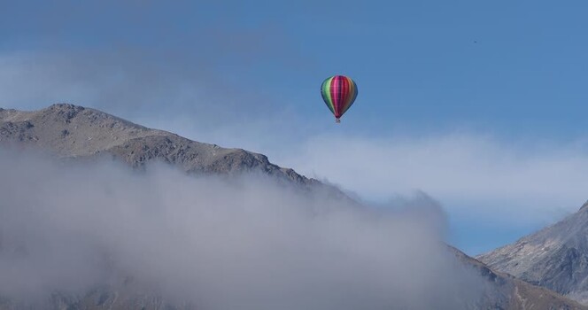 View of a colorful hot air balloon over mountains New Zealand. View of a colorful hot air balloon over mountains New Zealand.