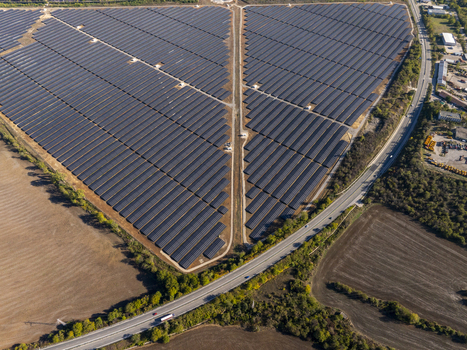 Aerial view of a large scale solar farm with rows of photovoltaic panels arranged in geometric patterns situated near a highway in the rural landscape of Lovech Lovech Bulgaria. Aerial view of a large scale solar farm with rows of photovoltaic panels arranged in geometric patterns situated near a highway in the rural landscape of Lovech Lovech Bulgaria.