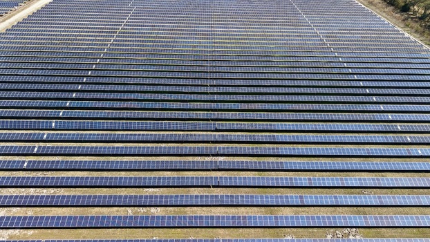 Aerial view of a vast solar panel array stretching into the horizon reflecting the sky in stark contrast to the dry earth Elkton Florida United States. Aerial view of a vast solar panel array stretching into the horizon reflecting the sky in stark contrast to the dry earth Elkton Florida United States.