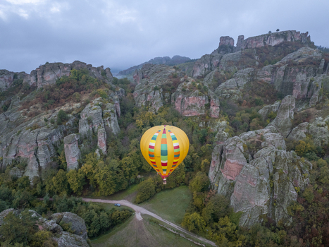 Aerial view of a colorful hot air balloon floating above the unique sandstone formations of the Belogradchik Rocks in Belogradchik Vidin Bulgaria.
