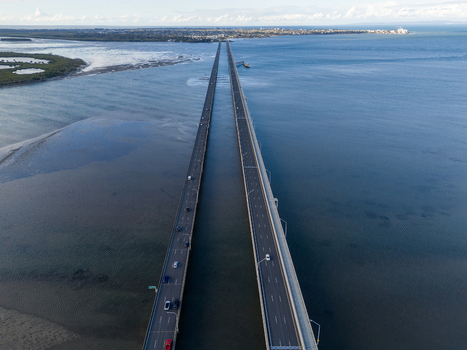 Aerial view of the Ted Smout Memorial Bridge spanning the calm waters of Bramble Bay with cars driving on the multi lane highway in Brighton Queensland Australia. Aerial view of the Ted Smout Memorial Bridge spanning the calm waters of Bramble Bay with cars driving on the multi lane highway in Brighton Queensland Australia.