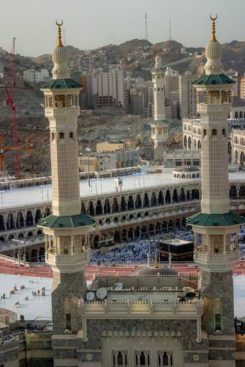 Aerial view of the Masjid al Haram featuring the Kaaba and its towering minarets with the urban landscape of Makkah in the background Makkah Makkah Province Saudi Arabia. Aerial view of the Masjid al Haram featuring the Kaaba and its towering minarets with the urban landscape of Makkah in the background Makkah Makkah Province Saudi Arabia.