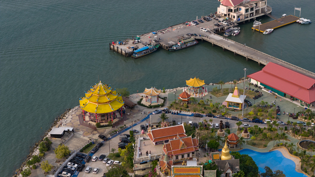 Aerial view of Koh Loi island with its yellow roofed Chinese temple and traditional Thai architecture near a busy pier in Si Racha Chon Buri Thailand. Aerial view of Koh Loi island with its yellow roofed Chinese temple and traditional Thai architecture near a busy pier in Si Racha Chon Buri Thailand.