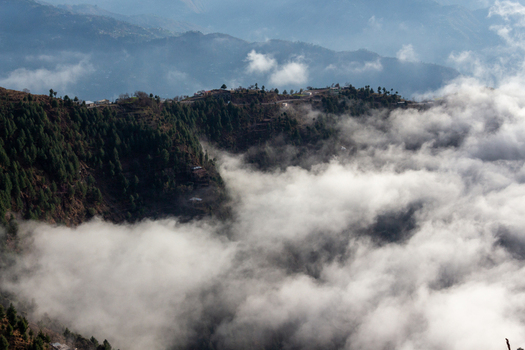 View of a mountain village perched high above a sea of swirling clouds where the crisp air meets the rugged terrain in Pir Chanasi Azad Kashmir Pakistan. View of a mountain village perched high above a sea of swirling clouds where the crisp air meets the rugged terrain in Pir Chanasi Azad Kashmir Pakistan.