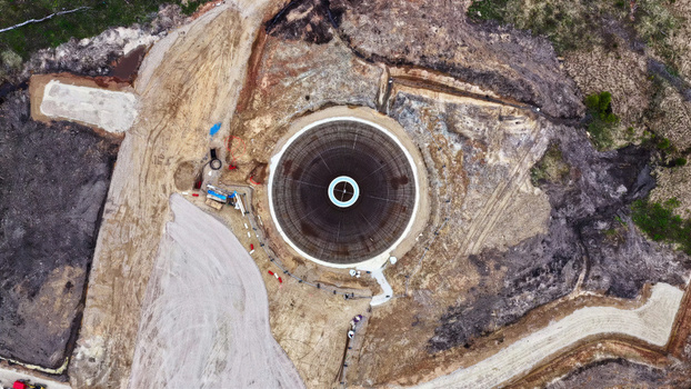 Aerial view of a circular wind turbine foundation under construction with exposed rebar and concrete surrounded by excavated earth and soil in Latvija. Aerial view of a circular wind turbine foundation under construction with exposed rebar and concrete surrounded by excavated earth and soil in Latvija.