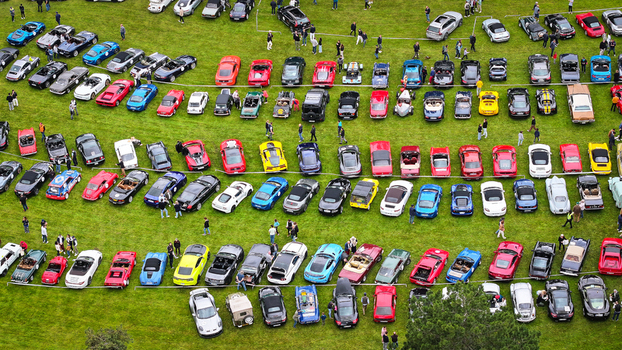 La Chapelle de Guinchay France 01 June 2024 Aerial view of a large gathering of colorful luxury sports cars parked in rows on a green field during a car show with people walking around. La Chapelle de Guinchay France 01 June 2024 Aerial view of a large gathering of colorful luxury sports cars parked in rows on a green field during a car show with people walking around.