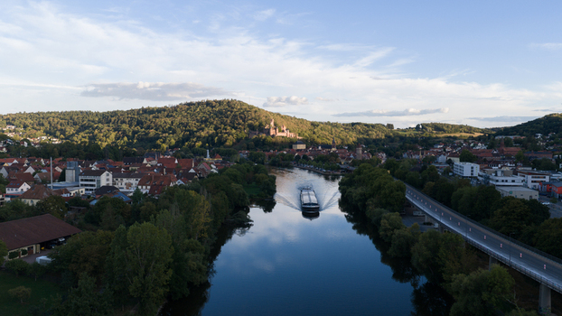 Aerial view of Wertheim Castle overlooking the town and the Main River with a cargo boat sailing through the water in Wertheim Baden Wurttemberg Germany. Aerial view of Wertheim Castle overlooking the town and the Main River with a cargo boat sailing through the water in Wertheim Baden Wurttemberg Germany.