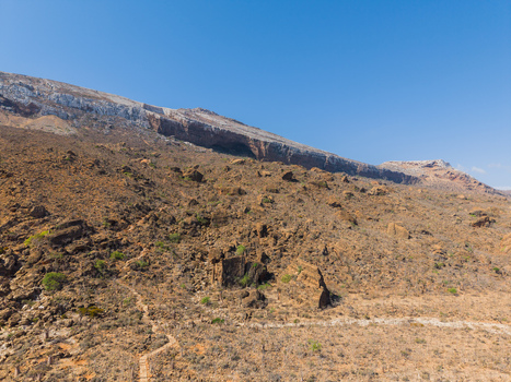 Aerial view of the rugged terrain of Socotra reveals a stark contrast between the arid landscape and the clear blue sky Rhiy di Hoq Socotra Yemen.