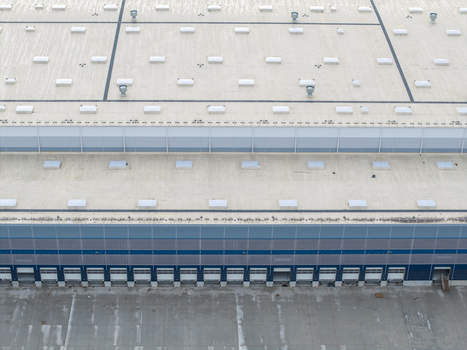 Aerial view of a modern logistics hub with numerous loading docks a large flat roof with ventilation units and a paved yard in Skawina Lesser Poland Voivode Poland. Aerial view of a modern logistics hub with numerous loading docks a large flat roof with ventilation units and a paved yard in Skawina Lesser Poland Voivode Poland.