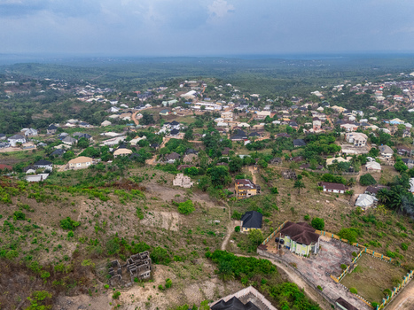 Aerial view of homes scattered among the lush green landscape creating a serene suburban tapestry under a soft overcast sky Ohafia Abia Nigeria. Aerial view of homes scattered among the lush green landscape creating a serene suburban tapestry under a soft overcast sky Ohafia Abia Nigeria.