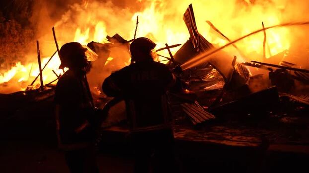 View of firefighters battling a large fire at night Bangladesh. View of firefighters battling a large fire at night Bangladesh.