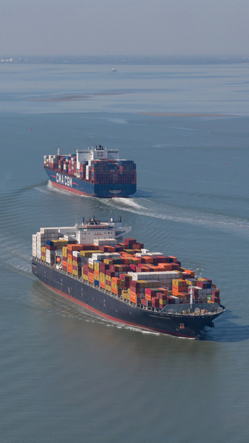 Terneuzen Netherlands 08 April 2026 Aerial view of two large container ships navigating the calm waters of the Western Scheldt under a clear blue sky. Terneuzen Netherlands 08 April 2026 Aerial view of two large container ships navigating the calm waters of the Western Scheldt under a clear blue sky.