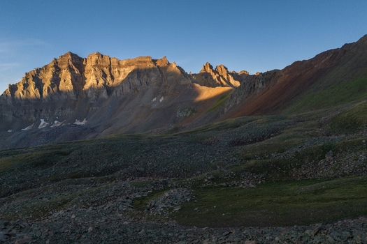Aerial view of Mount Sneffels in the San Juan Mountains featuring rugged rocky peaks and golden hour light illuminating the ridge in Yankee Boy Basin Ouray County Colorado United States. Aerial view of Mount Sneffels in the San Juan Mountains featuring rugged rocky peaks and golden hour light illuminating the ridge in Yankee Boy Basin Ouray County Colorado United States.
