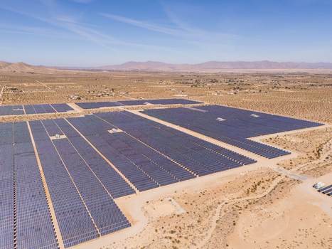 Aerial view of a vast solar farm with rows of blue panels stretching across the arid desert landscape under a clear sky Lucerne Valley California United States. Aerial view of a vast solar farm with rows of blue panels stretching across the arid desert landscape under a clear sky Lucerne Valley California United States.
